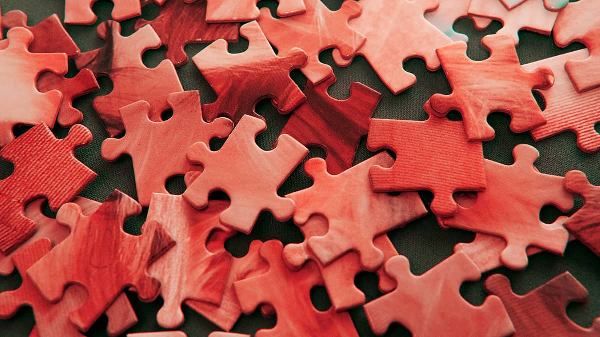 Image showing a pile of red-hued jigsaw puzzle pieces.